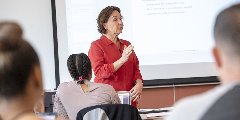 A professor lecturing to a classroom full of students