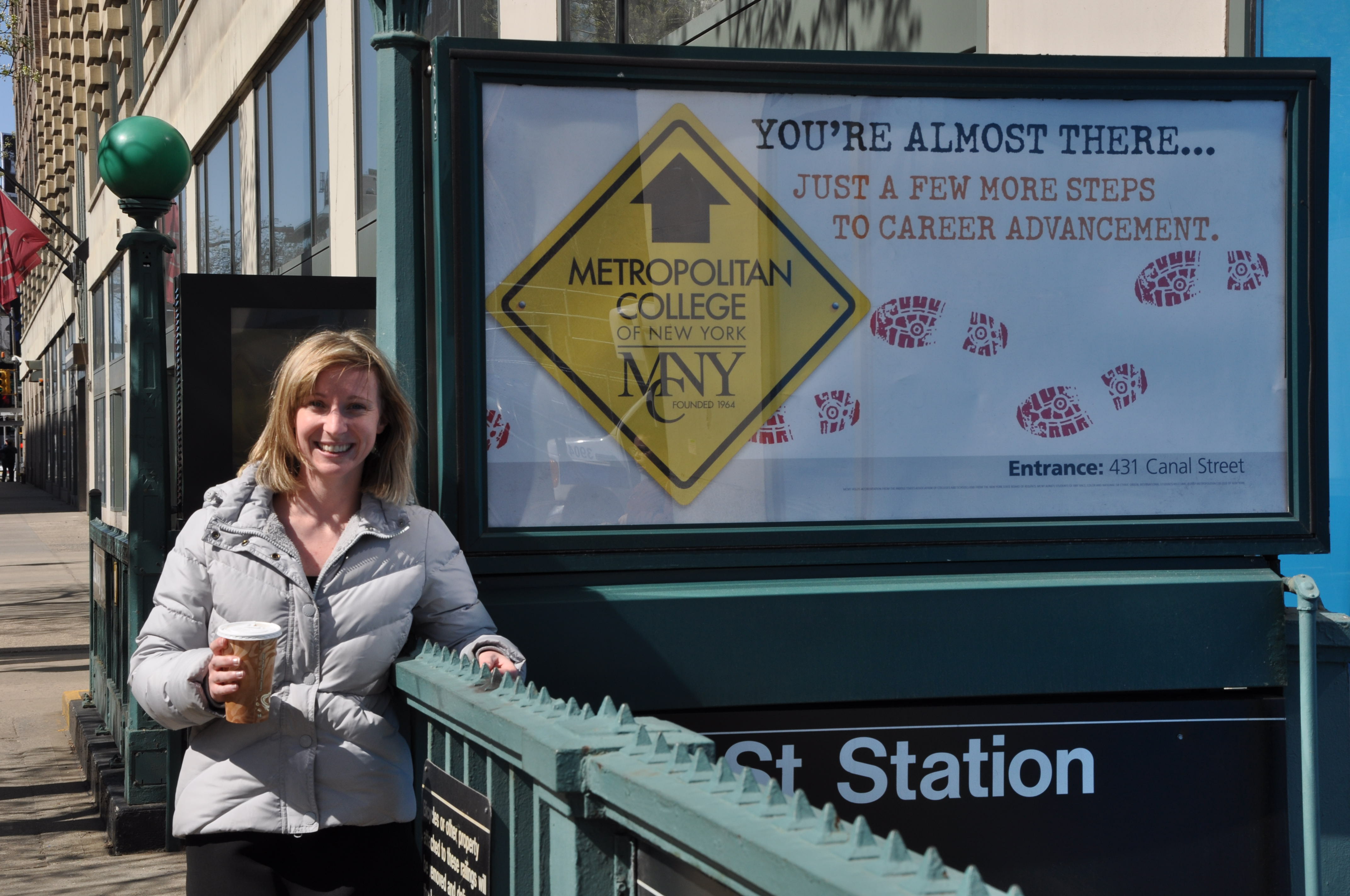 Hana Lahr poses with a subway ad for MCNY, where she was an advisor and coordinator of student life