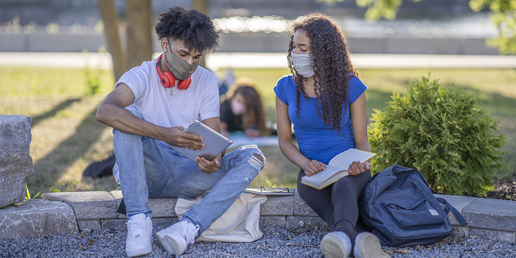 Two students in masks study together