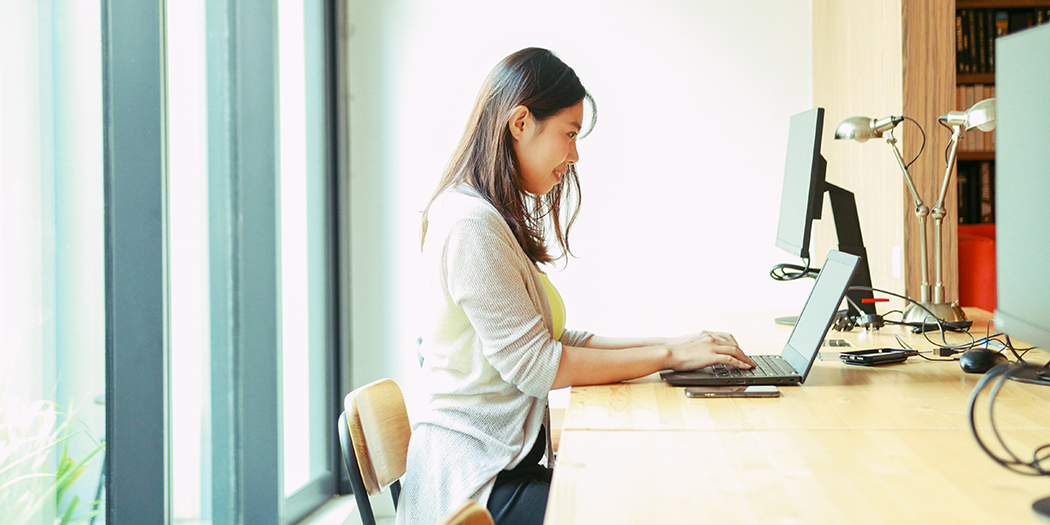 A woman works remotely at her computer