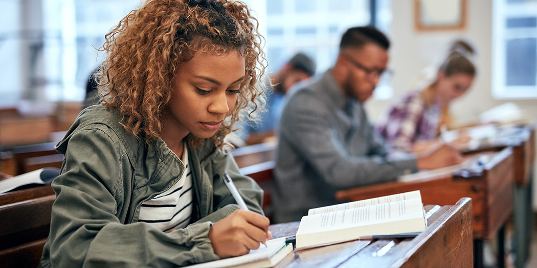 A group of students take notes in class