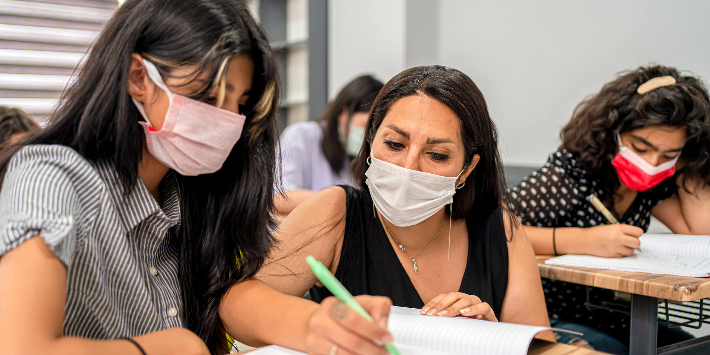 A teacher working with a student on an in-class writing assignment