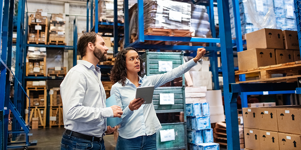 Two people walk in a warehouse