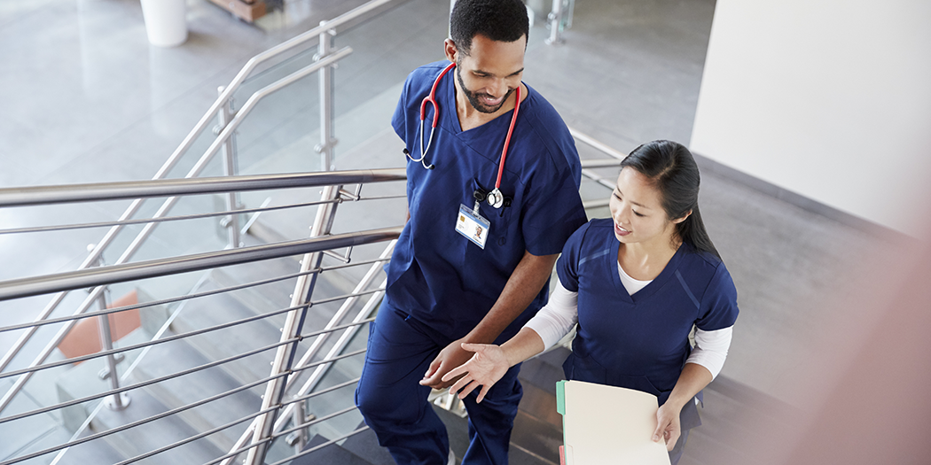 Nurses in scrubs walk and talk