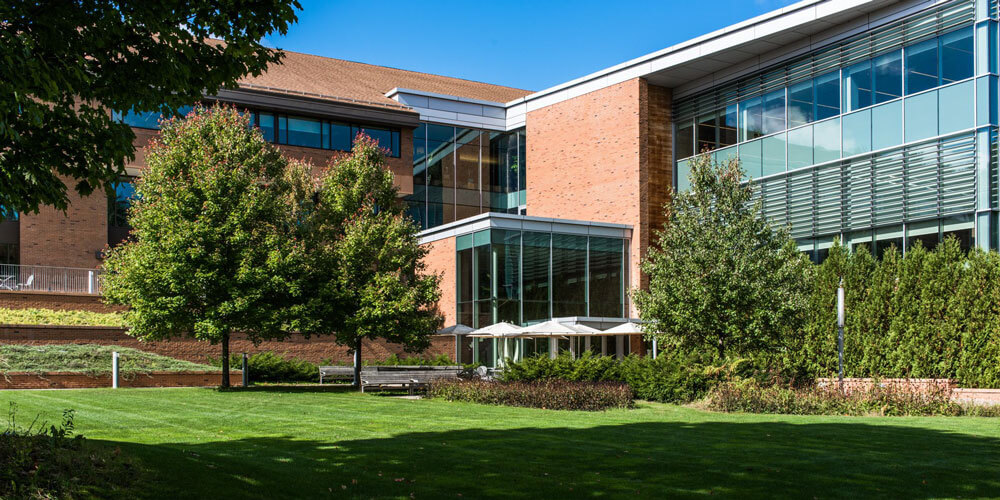 Image of Greenfield Community College building with blue skies and grass