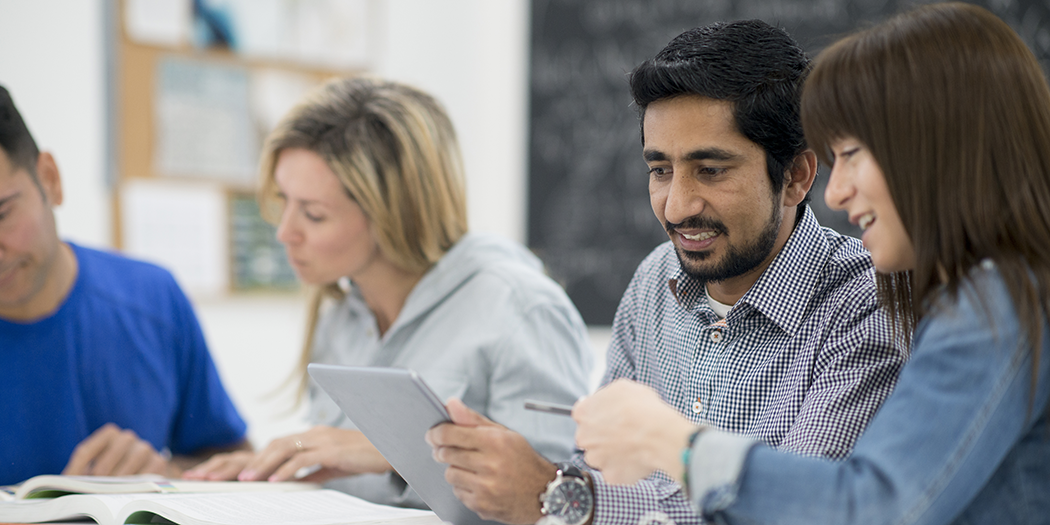 Adult students work together in class