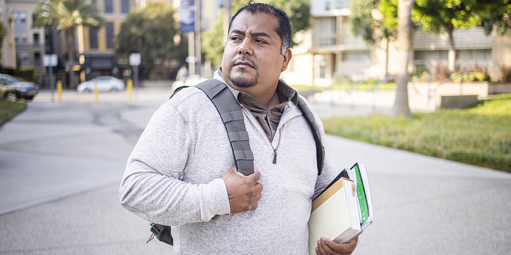 A student carries books on campus