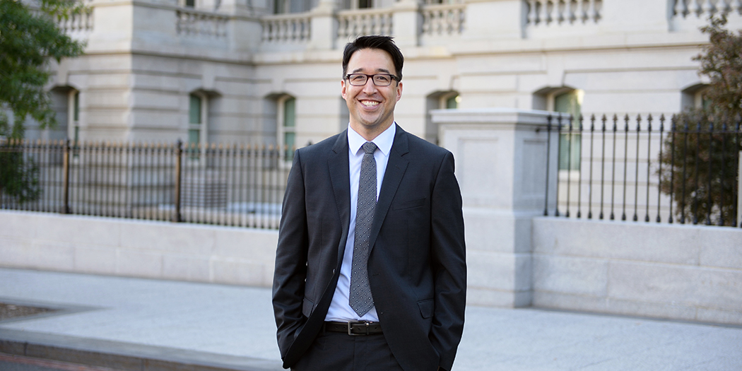 Jordan Matsudaira in a suit outside a government building in Washington, DC