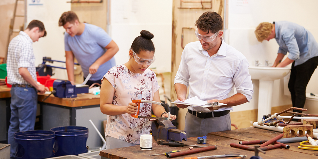 Teacher demonstrating for students in a plumbing classroom