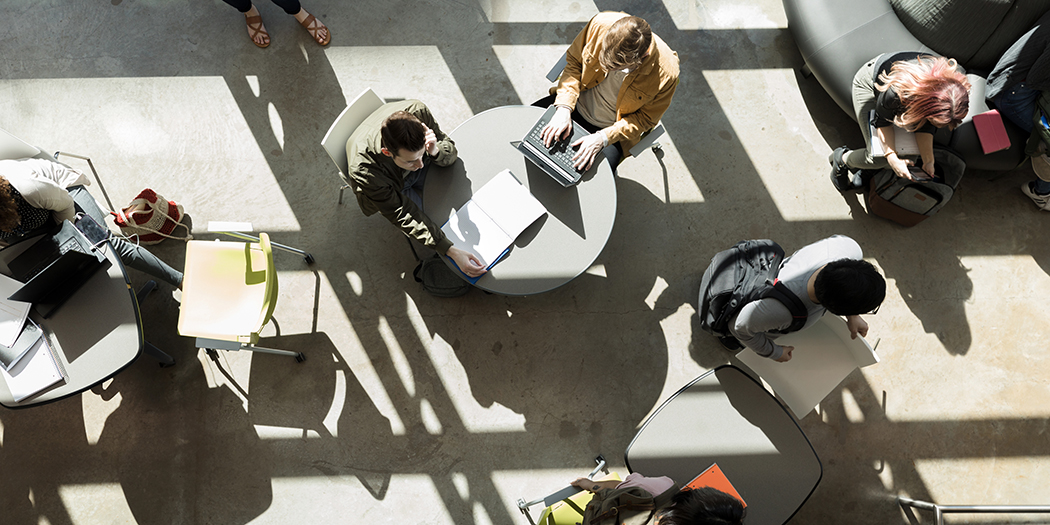 An overhead shot of students studying at tables 